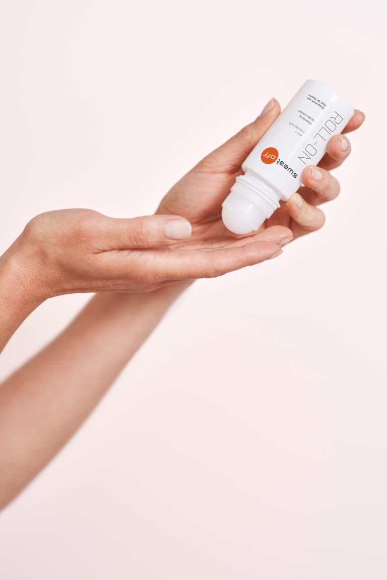 Antitranspirant Roll-On geöffnet und wird auf einer Hand aufgetragen