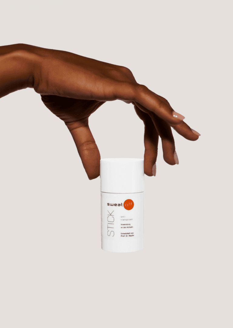 Hand hält Antitranspirant Stick zwischen den Fingern