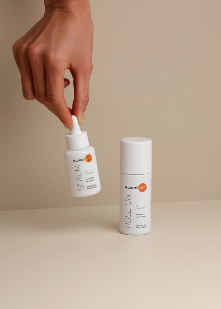 Serum wird von einer Hand hochgehalten, daneben steht der klassische Roll-On